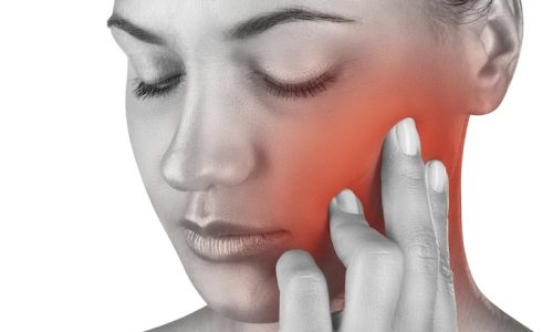 Young woman in pain is having a toothache isolated on white background